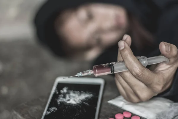 The woman holding the syringe and overdose , The concept of crime and drug addiction. 26 June, International Day Against Drug Abuse and Illicit Trafficking