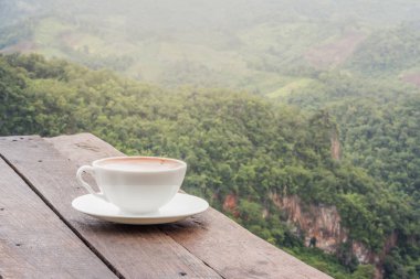 Bir fincan kahve tablo ve güzel dağ arka plan.