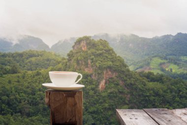 Bir fincan kahve tablo ve güzel dağ arka plan.