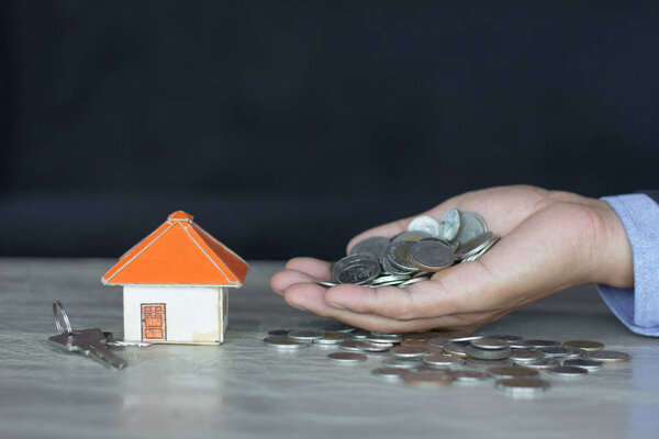 Модели домов и монеты в человеческих руках, ипотечная концепция денежного дома из монет
.
