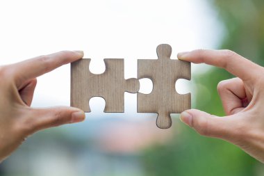 İki el çift bağlanmaya çalışıyor yeşil arka plana sahip parça puzzle. Dernek ve bağlantı sembolü. iş stratejisi.