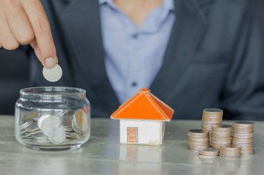 para içinde ev, gayrimenkul konsept koyarak ver. El madeni para ve ev.