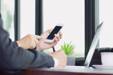 akıllı telefon ve dizüstü bilgisayar üzerinde çalışan iş adam el