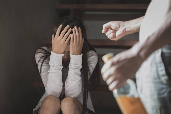 Пьяный мужчина жестоко нападает на свою жену в углу комнаты, концепция насилия в отношении женщин и домашнего насилия
.