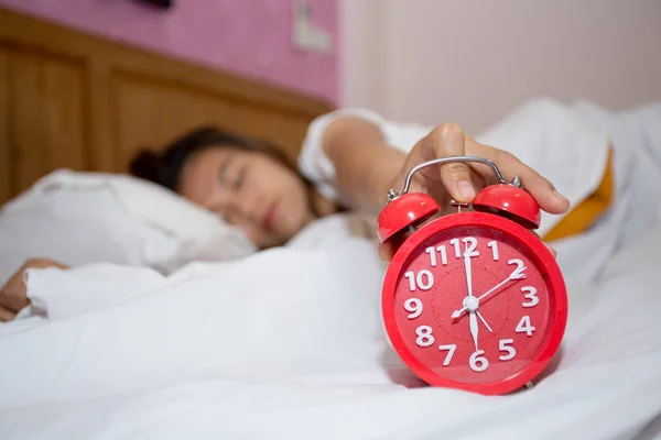 スヌーズを停止しようとして眠っている怠惰な女性と寝室の目覚まし時計 朝の概念 不眠症睡眠 心配とストレスの概念 — ストック写真