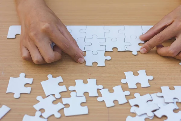 Close up of hands business women connecting jigsaw puzzleon, Teamwork workplace success and strategy concept.