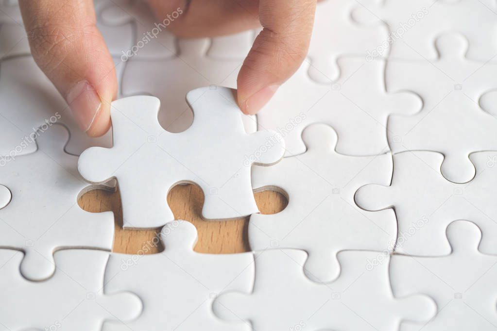 Hand put the last piece of jigsaw puzzle to complete the mission, Business solutions, success and strategy concept
