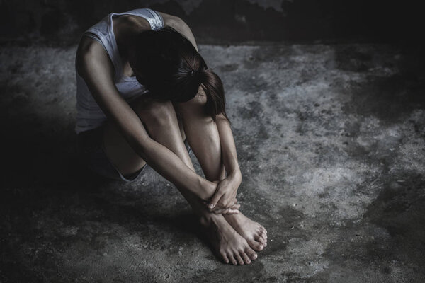 The depressed teen sat on the floor, stressed sad young woman having mental problems,Domestic Violence and Trafficking