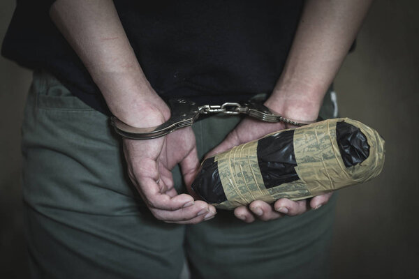 Наркоторговцы были арестованы вместе с героином. Полиция арестовывает наркоторговца с наручниками. Концепция закона и полиции, 26 июня, Международный день борьбы с наркоманией и незаконным оборотом наркотиков
