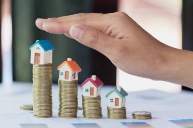 El koruması, mortgage kredisi, mülkiyet yönetimi kavramı büyüme olarak para yığını üstünde ev modeli. Yatırım ve Risk Yönetimi.