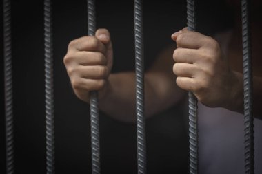 Hapishane elleri adam hapse barlar çelik kafes tutun, Erkek mahkumlar ciddi gergin karanlık hapishane, şiddet, insan ticareti, hapishane ve mahkum kavramı içinde.