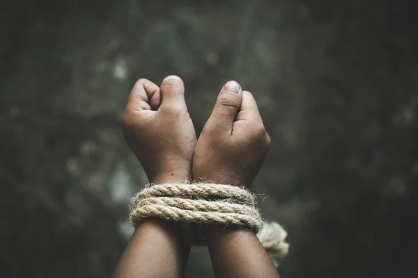 Hands tied up with rope of a missing kidnapped, abused, Violence against children, victim child in pain, human trafficking Concept.