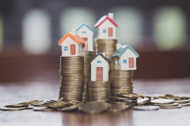 Bozuk para, ev, ipotek, ev almak için biriktirilen para ve emlak konseptine yatırılan kredilerin olduğu küçük bir ev. Invesment ve Risk Yönetimi.