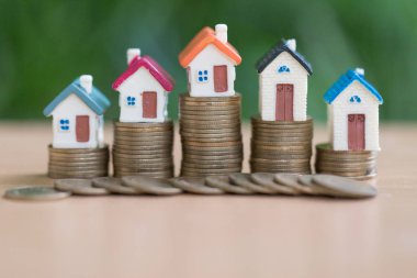 Bozuk para, ev, ipotek, ev almak için biriktirilen para ve emlak konseptine yatırılan kredilerin olduğu küçük bir ev. Invesment ve Risk Yönetimi.