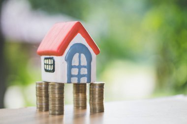 Bozuk para, ev, ipotek, ev almak için biriktirilen para ve emlak konseptine yatırılan kredilerin olduğu küçük bir ev. Invesment ve Risk Yönetimi.