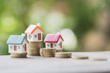 Bozuk para, ev, ipotek, ev almak için biriktirilen para ve emlak konseptine yatırılan kredilerin olduğu küçük bir ev. Invesment ve Risk Yönetimi.