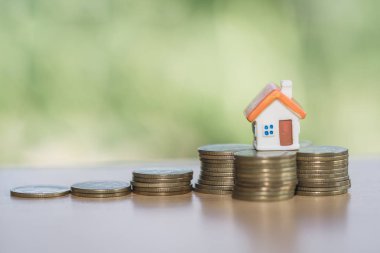 Bozuk para, ev, ipotek, ev almak için biriktirilen para ve emlak konseptine yatırılan kredilerin olduğu küçük bir ev. Invesment ve Risk Yönetimi.