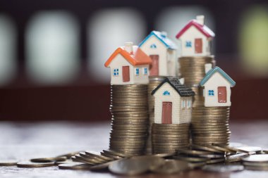 Bozuk para, ev, ipotek, ev almak için biriktirilen para ve emlak konseptine yatırılan kredilerin olduğu küçük bir ev. Invesment ve Risk Yönetimi.