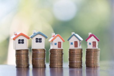 Bozuk para, ev, ipotek, ev almak için biriktirilen para ve emlak konseptine yatırılan kredilerin olduğu küçük bir ev. Invesment ve Risk Yönetimi.