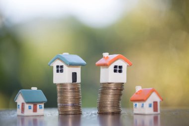 Bozuk para, ev, ipotek, ev almak için biriktirilen para ve emlak konseptine yatırılan kredilerin olduğu küçük bir ev. Invesment ve Risk Yönetimi.