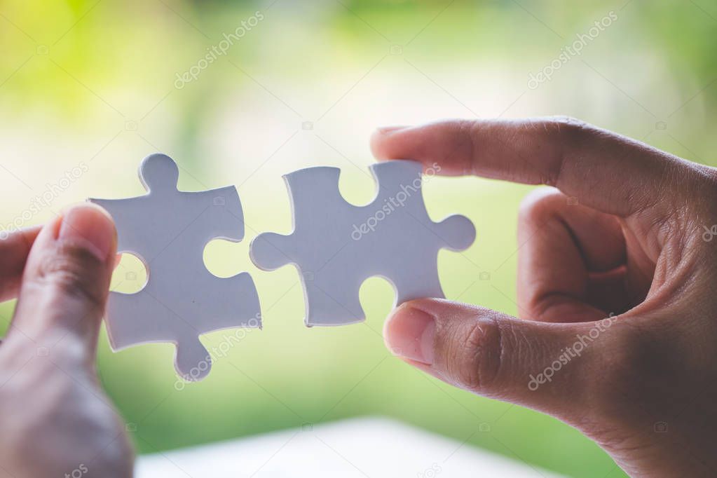 Closeup hand of man connecting jigsaw puzzle with sunlight effect, Business solutions, success and strategy concept