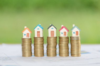 Bozuk para, ev, ipotek, ev almak için biriktirilen para ve emlak konseptine yatırılan kredilerin olduğu küçük bir ev. Invesment ve Risk Yönetimi.