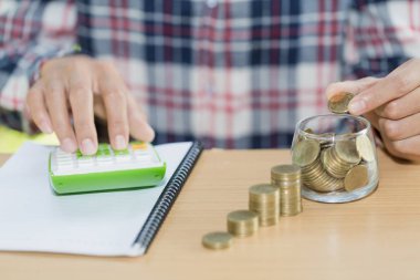 Paralar sürahi cam, işadamı yazma finansal muhasebe, kavram olarak finansal koyarak el ile para tasarrufu ile iş rapor