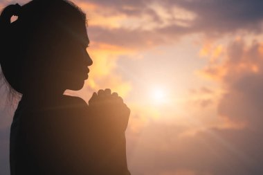 Güneş doğarken, Christian Religion kavramı arka plan Tanrı'ya dua genç insan eli silüeti.