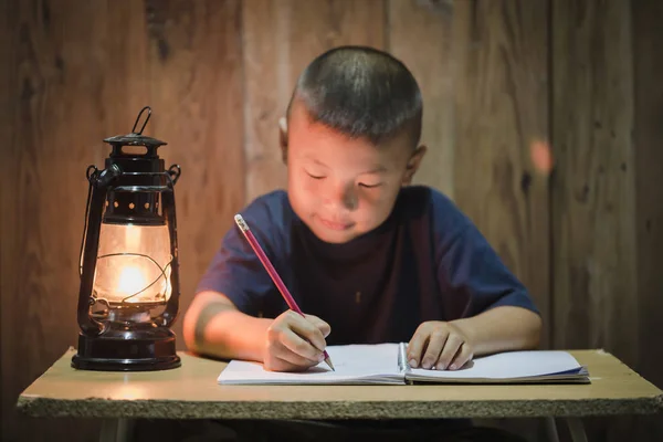 Poor children write books illuminating with oil lamps, Disadvantaged Children doing homework, Education Concept.