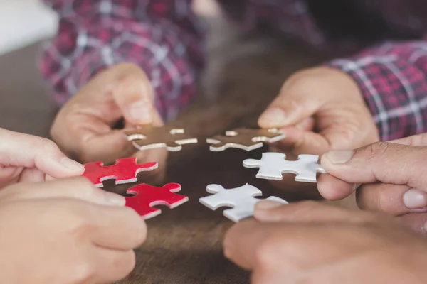 Business people Holding Jigsaw Puzzle, group of business people using a jigsaw puzzle to demonstrate the need to work in the same direction to work fully and effectively