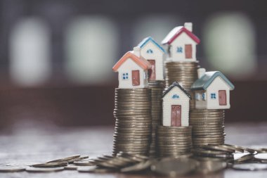 Bozuk para, ev, ipotek, ev almak için biriktirilen para ve emlak konseptine yatırılan kredilerin olduğu küçük bir ev. Invesment ve Risk Yönetimi.