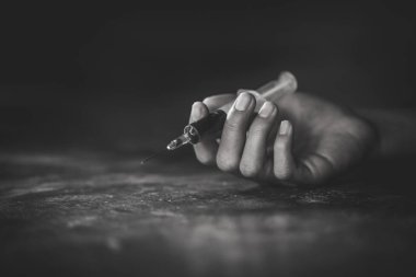 Bir uyuşturucu bağımlısı ve bir şırınga narkotik şırınga yerde, aşırı dozda uyuşturucu kavramı ile el kadın.