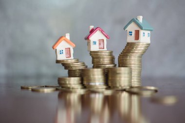 Bozuk para, ev, ipotek, ev almak için biriktirilen para ve emlak konseptine yatırılan kredilerin olduğu küçük bir ev. Invesment ve Risk Yönetimi.
