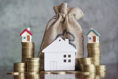 Bozuk para, ev, ipotek, ev almak için biriktirilen para ve emlak konseptine yatırılan kredilerin olduğu küçük bir ev. Invesment ve Risk Yönetimi.