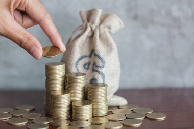 Closeup el koymak yığmak için paraları sikke, para tasarrufu kavramı. Para tasarrufu