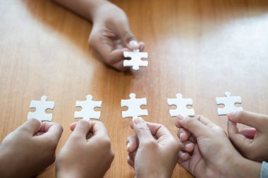 Yapboz tutan iş adamları, yapboz kullanan bir grup iş adamı tam ve etkili bir şekilde çalışmak için aynı yönde çalışma ihtiyacını gösteriyorlar.