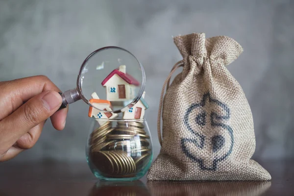 House searching concept with a magnifying glass, house and money. magnifying glass and coins. concept of mortgage, construction, rental housing.