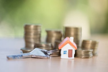 Evin anahtarı ve mini ev, gayrimenkul yatırım, tasarruf yığını bozuk para, iş büyüme yatırım ve Finansal Kiralama ev, ipotek kavramı ile. 