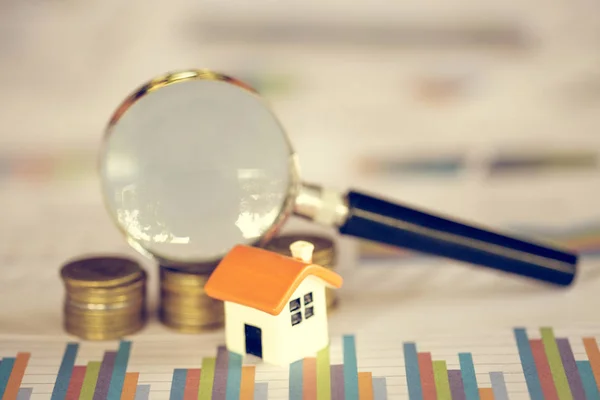 House searching concept with a magnifying glass, house and money. magnifying glass and coins. concept of mortgage, construction, rental housing.