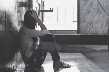 Yatak odasının köşesinde oturan korkmuş genç bir kadın, çaresizce tecavüz mağduru yardım bekliyor, kadınlara yönelik şiddeti ve tecavüzü durdurma konsepti.. 