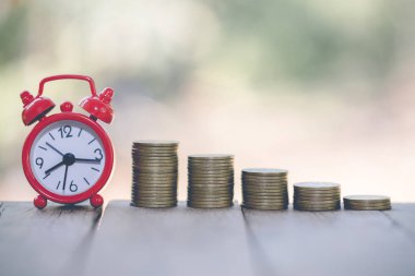 Çalar saat ve tablo, zaman tasarruf para kavramı, bankacılık ve iş, vintage sesi için para yığınları basamakta.