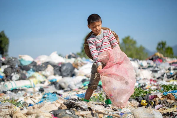 Pobre chico recogiendo basura en su saco para ganarse la vida , — Foto de Stock