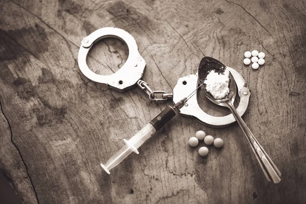 Drug syringe and cooked heroin on spoon and handcuffs . Concept — Stock Photo, Image