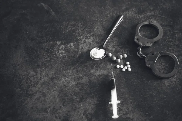 Jeringa de drogas y heroína cocida en cuchara y esposas. Concepto — Foto de Stock