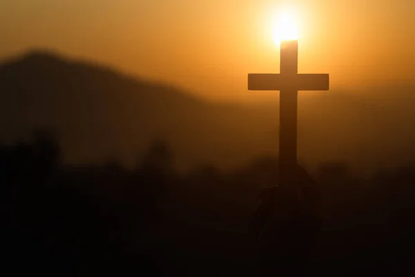 Woman hand holding holy lift of christian cross with light sunse — Stock Photo, Image