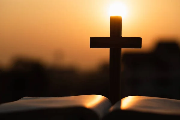 Silhueta da cruz de madeira sobre bíblia aberta com um s brilhante — Fotografia de Stock