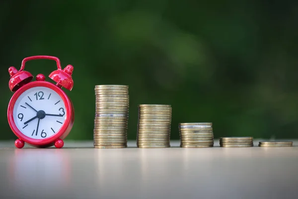 Alarm clock and step of coins stacks on table, time for savings — Stock Photo, Image