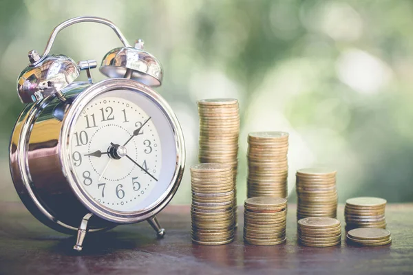 Alarm clock and step of coins stacks on table, time for savings — Stock Photo, Image