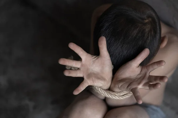 Abuso infantil, vítima menino com as mãos amarradas com corda na emoçãoa — Fotografia de Stock