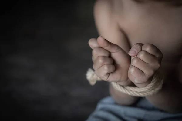 Abuso infantil, vítima menino com as mãos amarradas com corda na emoçãoa — Fotografia de Stock